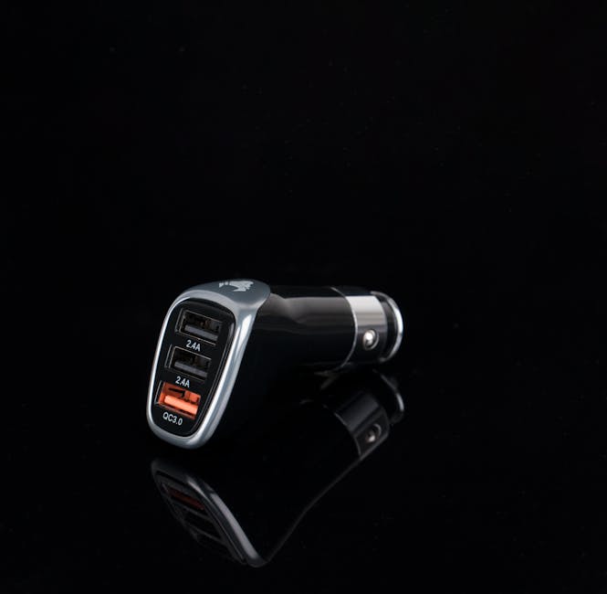 A close-up image of a black car cigarette lighter charger with two USB ports and an orange quick-charge port, placed on a reflective black surface. The charger is designed for in-car use, with the USB ports labeled for 2.4A charging and an orange QC3.0 port for fast charging. The background is solid black, highlighting the product without any additional objects. The image is suited for content related to vehicle accessories, portable charging devices, or logistics involved in home relocations where mobile device charging during moving or transport may be relevant, as seen on the page about avoiding hidden removals charges in Harringay with Harringay Man and Van.